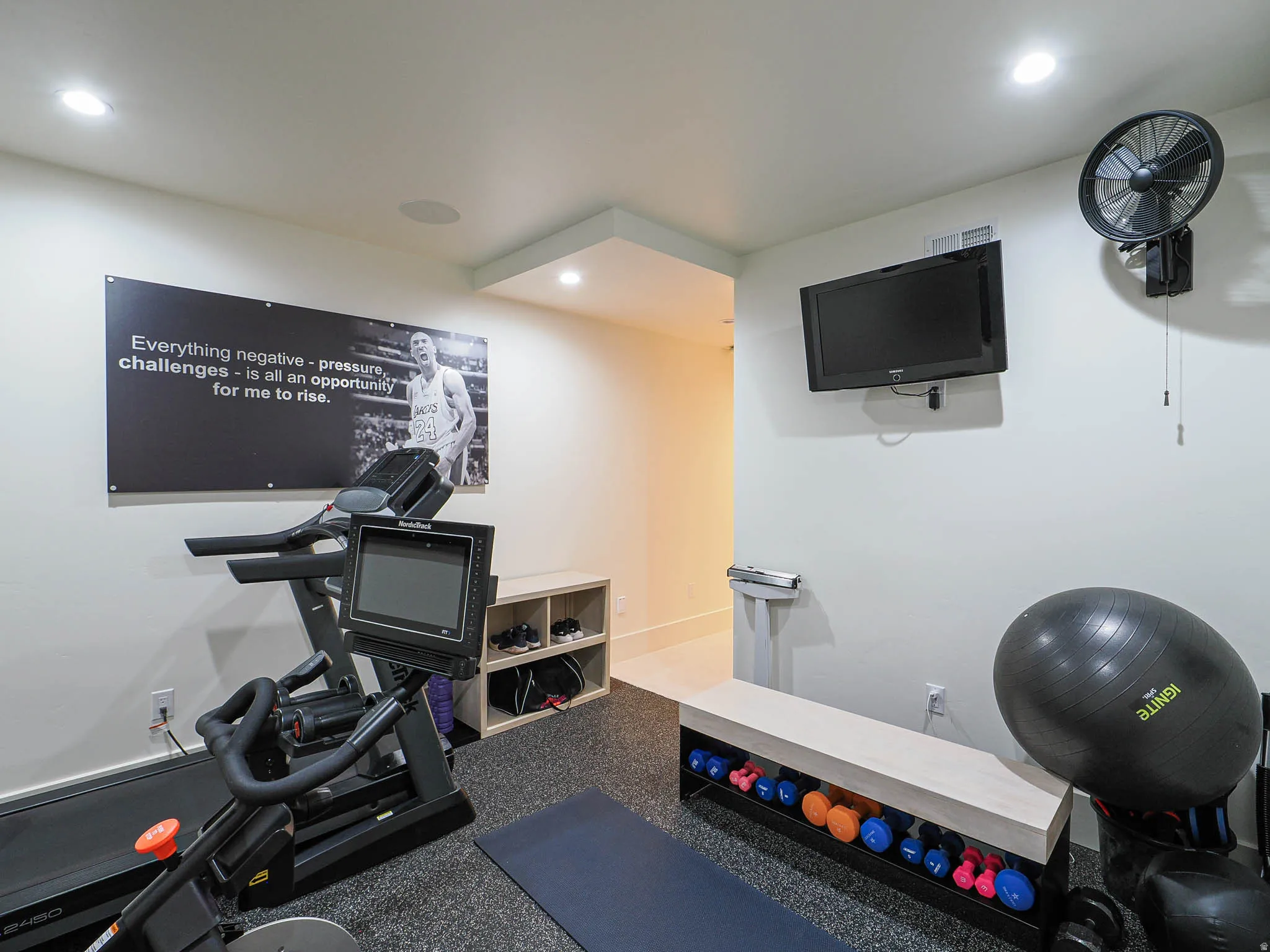 Recessed lighting, wall-mounted television, and a built-in wall fan