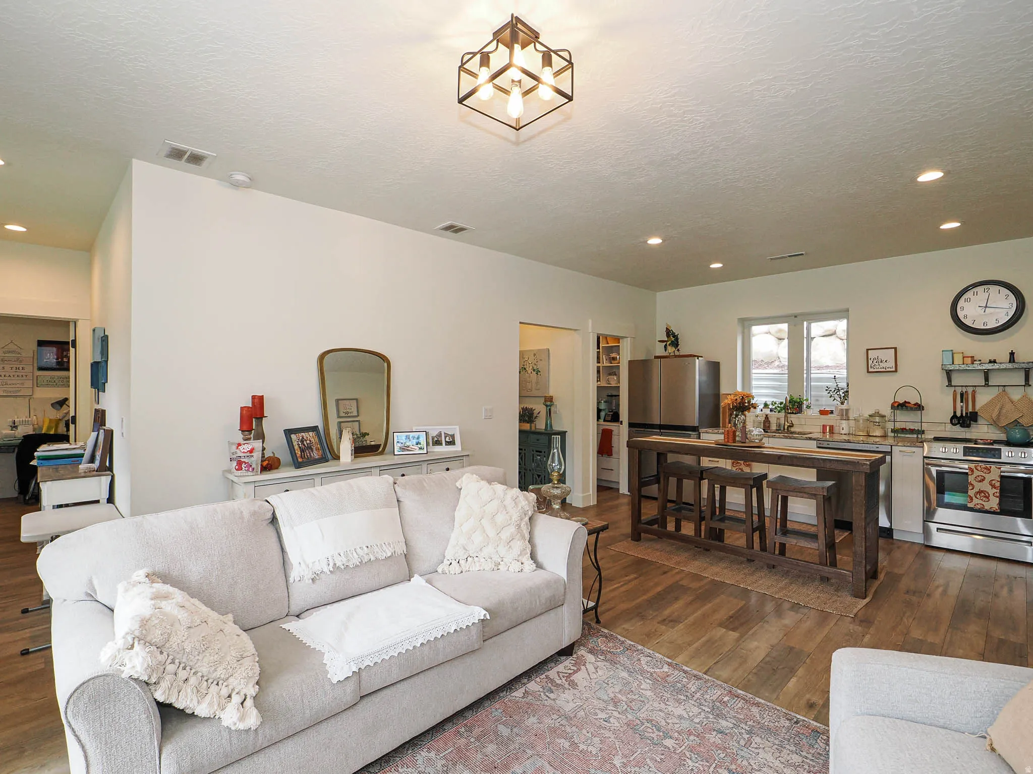 Recessed ceiling lighting, wood-finish flooring, stainless steel appliances, and a built-in kitchen island with seating