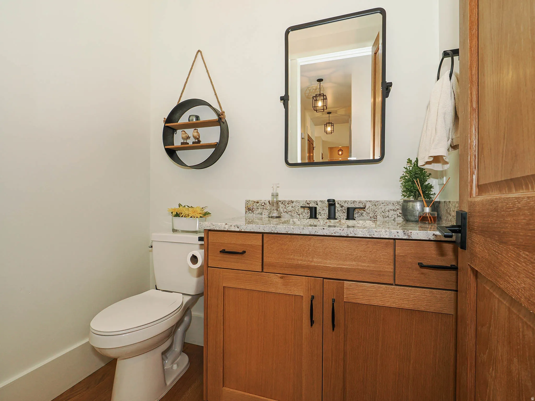 Wood-finish vanity with granite countertop and rectangular sink