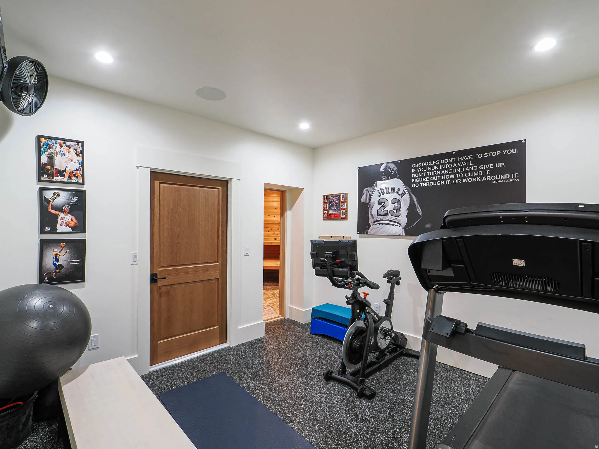 Recessed lighting, wood-finish interior doors, white trim, and speckled flooring