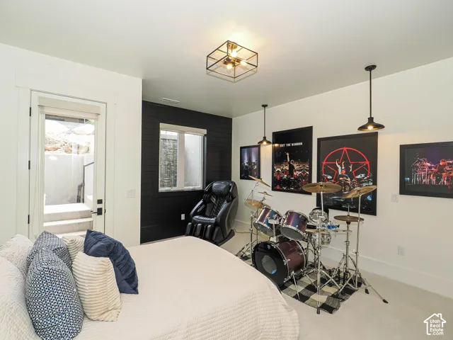 White walls with a black accent wall, ceiling-mounted light fixture, two pendant light fixtures, a window, and a door leading to exterior stairs