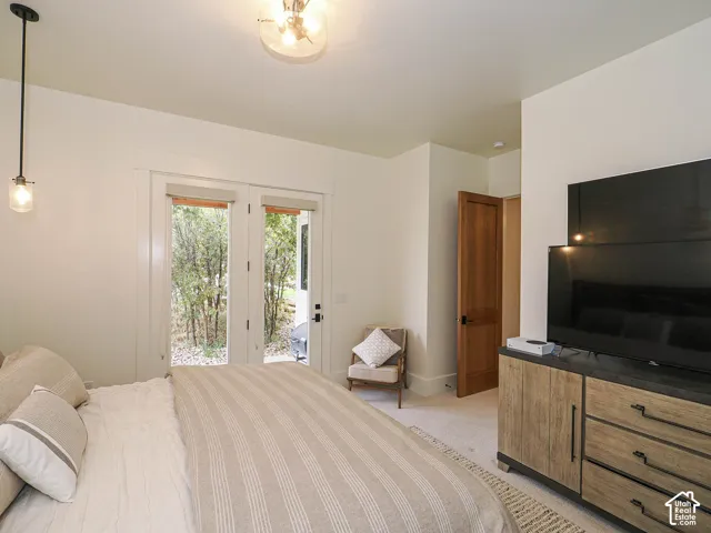 White walls with french doors, a built-in wood-finish dresser, a flush-mount ceiling light fixture, and a pendant light fixture