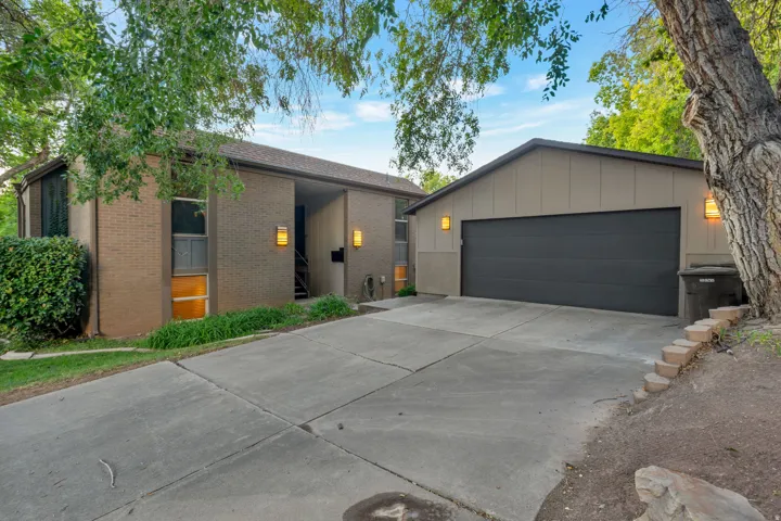 Brick exterior with integrated garage, concrete driveway, and exterior lighting fixtures