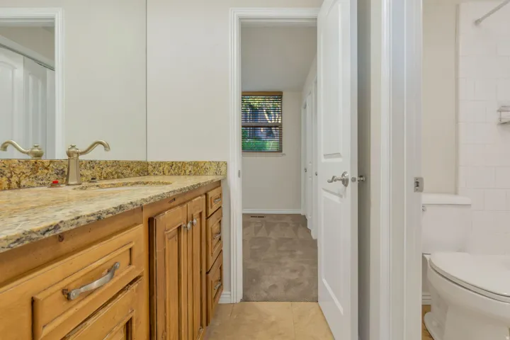 Vanity with a light-toned stone countertop, undermount sink, and brushed nickel faucet