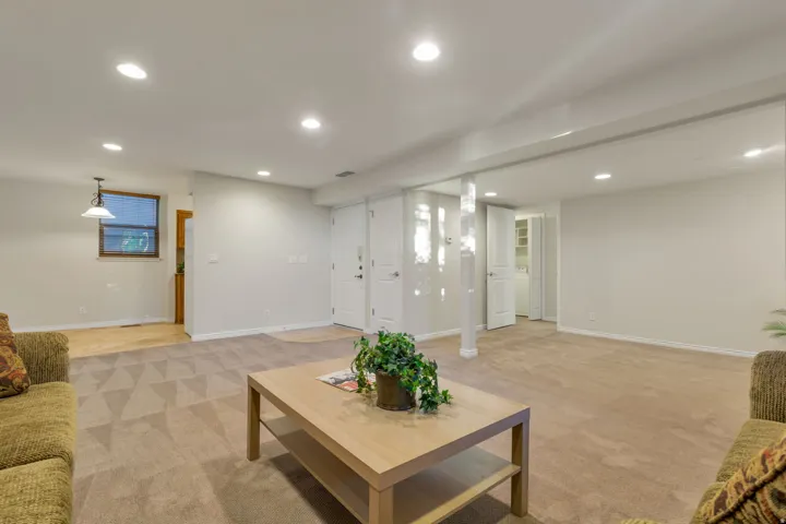 Recessed lighting, wood-finish flooring, white paneled doors, and painted walls
