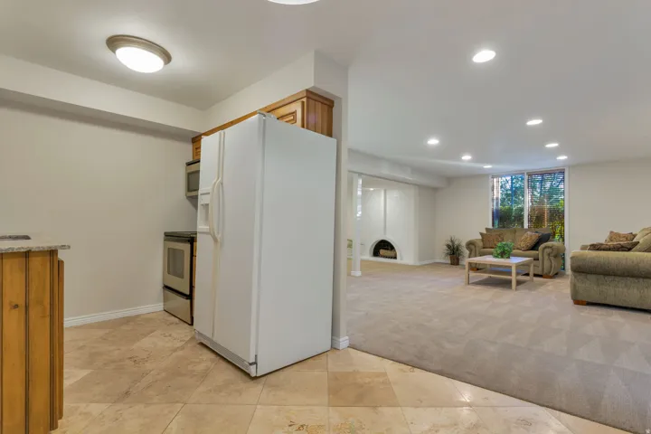 Kitchenette featuring wood cabinetry, stone countertops, and tile flooring