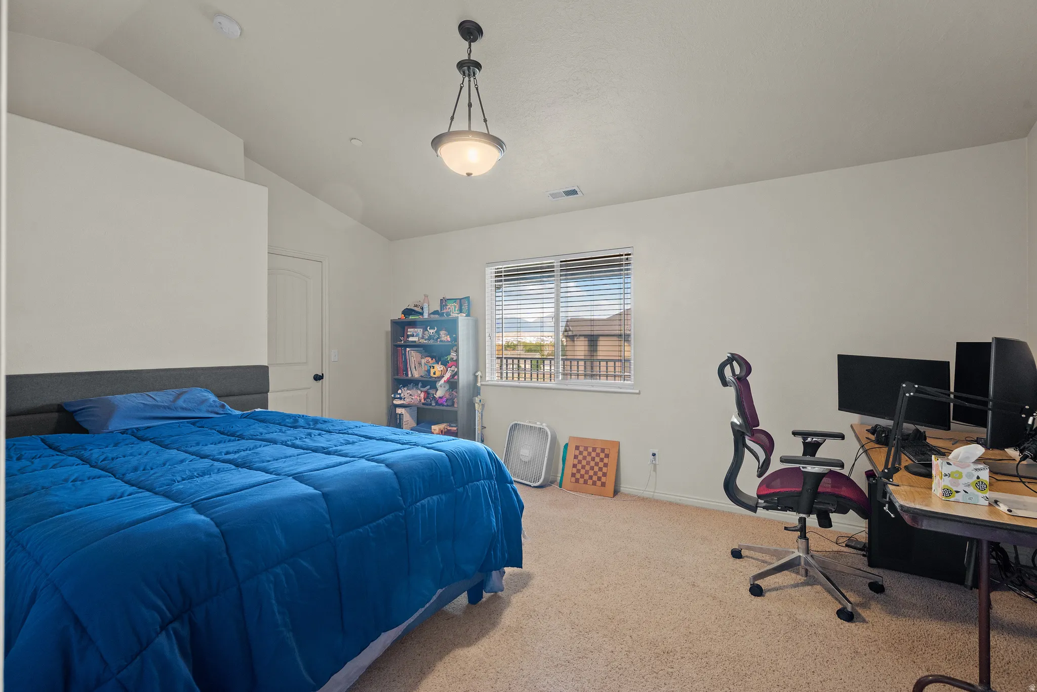 Sloped ceiling with an attached bowl-style light fixture, window with blinds, and neutral carpet
