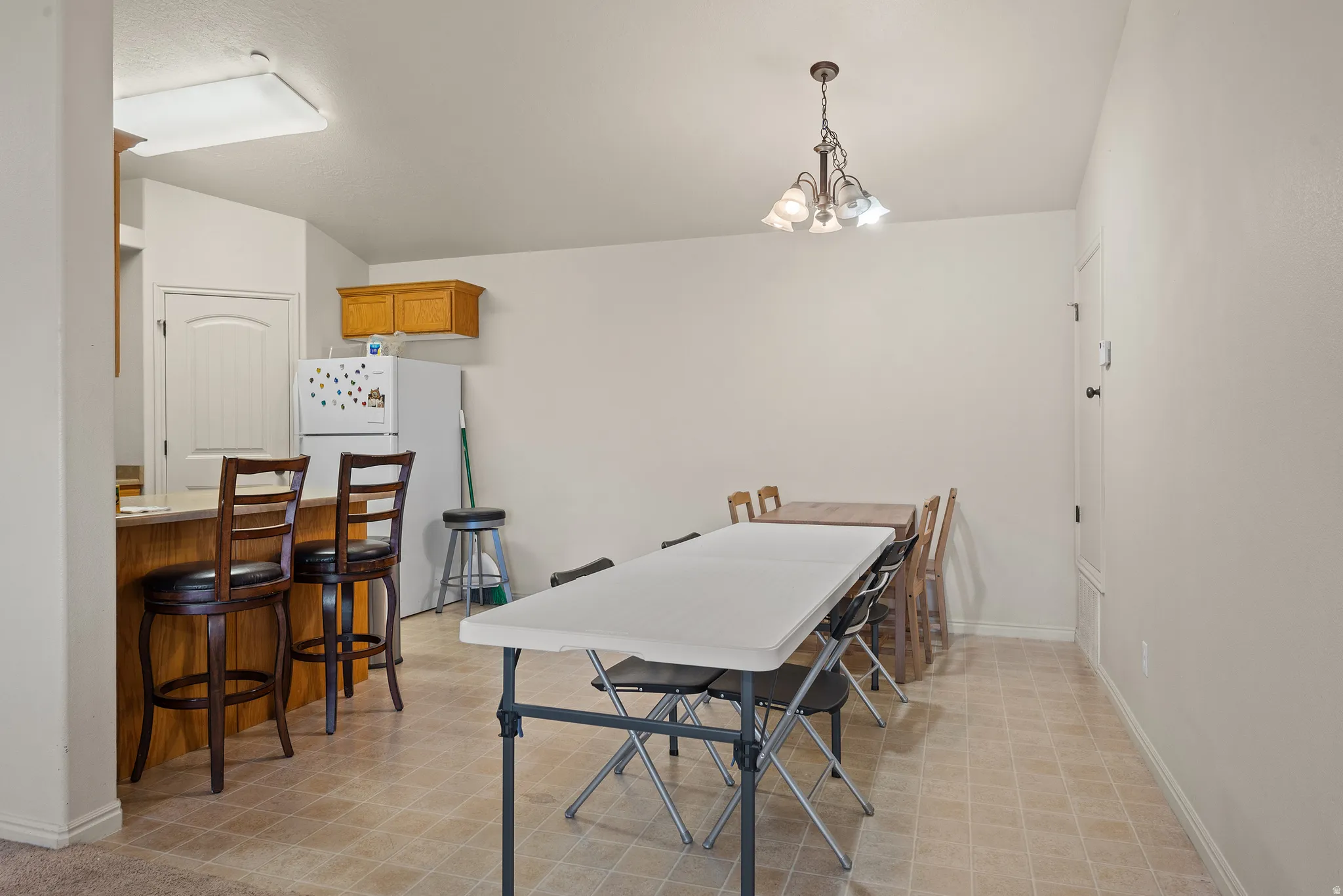 Built-in breakfast bar with wood-finish cabinetry, overhead lighting, and tile flooring