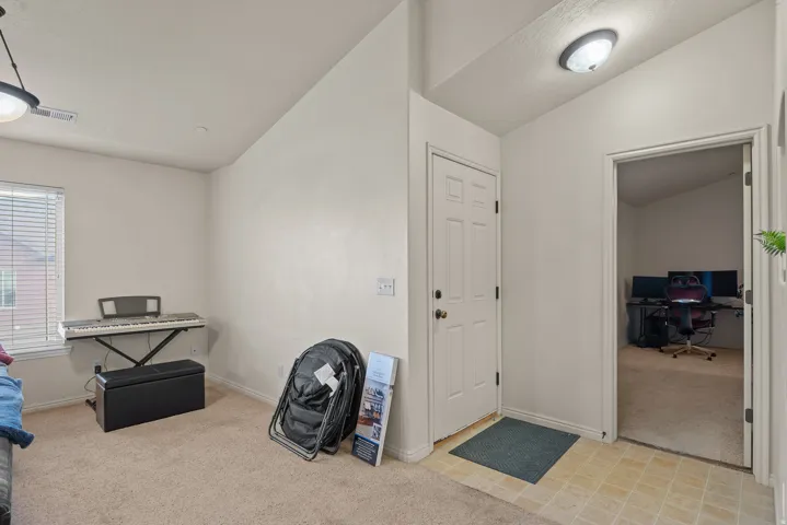 Entryway with paneled door, flush-mount lighting, and mixed flooring transitions to carpeted interior spaces