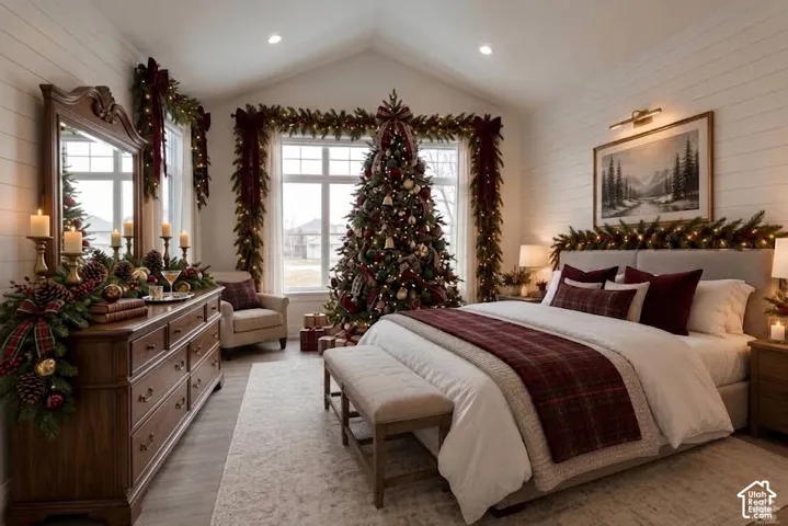 Vaulted ceiling with recessed lighting, shiplap accent wall, wood-finish flooring, multiple windows, and a built-in upholstered headboard