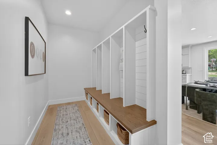 Built-in cubby storage with bench seating, shaker-style paneling, and wood-finish flooring