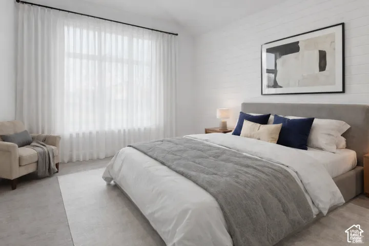 Expansive window with sheer curtain panels, textured accent wall, and recessed ceiling lighting