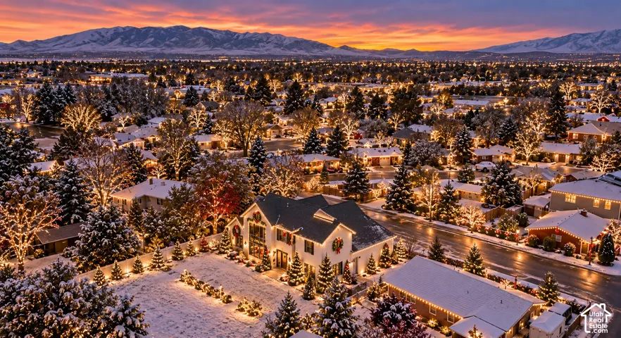 Expansive mountain backdrop with a neighborhood featuring mature trees and established street lighting