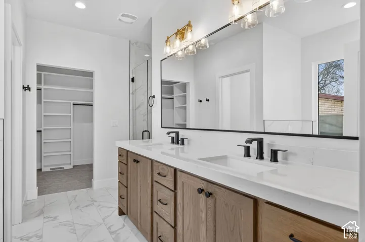 Dual vanity with wood-finish cabinetry, white countertops, and matte black fixtures