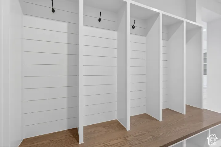Built-in storage cubbies featuring shiplap backing, integrated hooks, and wood-finish bench seating