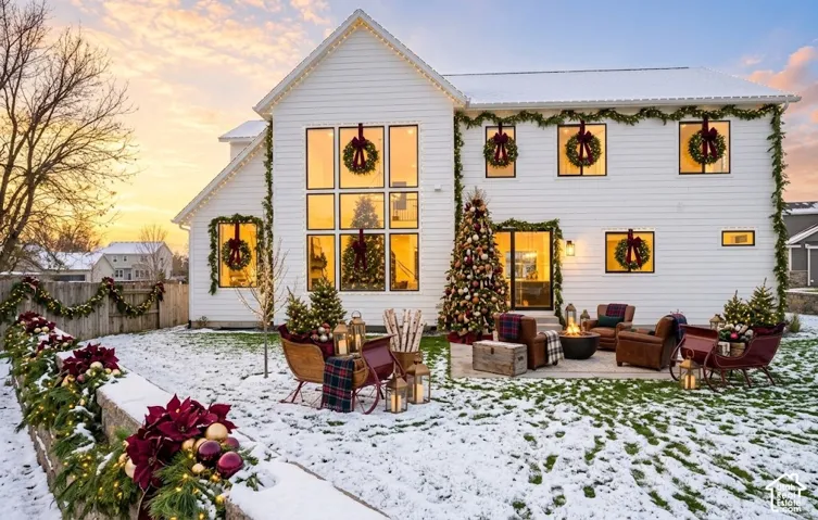 White horizontal siding exterior with a multi-level roofline, featuring a large window array and an exterior patio