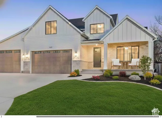 Modern farmhouse exterior featuring white siding, brick accents, and a covered front porch
