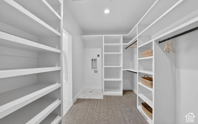 Built-in shelving, integrated closet rods, recessed ceiling lighting, and laundry appliance hookups