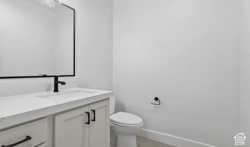 White vanity with shaker-style cabinetry, matte black hardware, integrated sink, and wall-mounted faucet