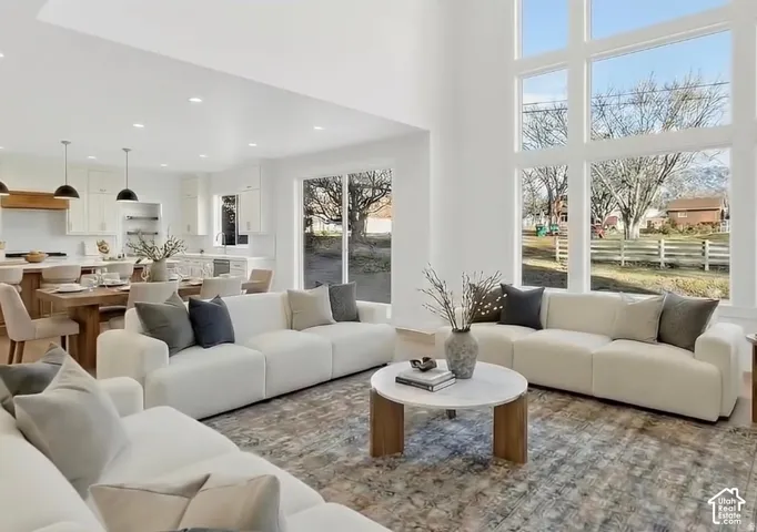 Soaring ceilings, expansive window wall, recessed lighting, wood-finish flooring, and open-concept design