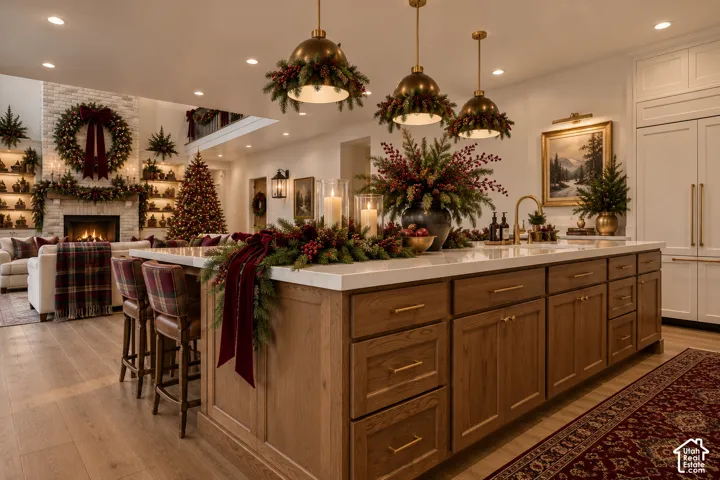 Open-concept living area with a stone-clad fireplace and wood-finish flooring
