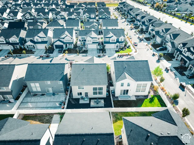 Aerial perspective showcasing multiple properties with dark-shingle roofs, light-toned exteriors, and private backyards