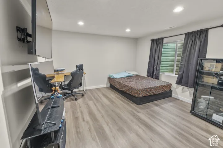 Recessed lighting, light gray wall paint, wood-finish flooring, and a large window