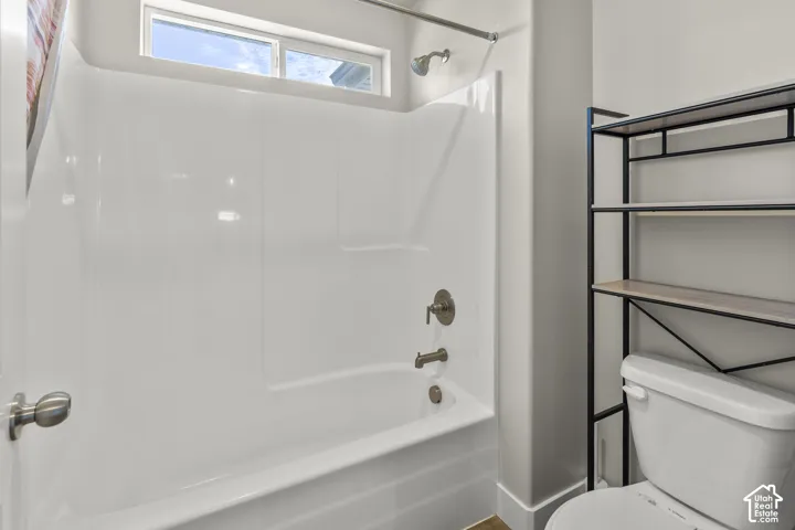 White fiberglass tub and shower combination with brushed bronze fixtures
