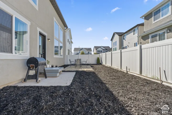 Private outdoor space featuring a concrete patio, dark mulch landscaping, and perimeter fencing