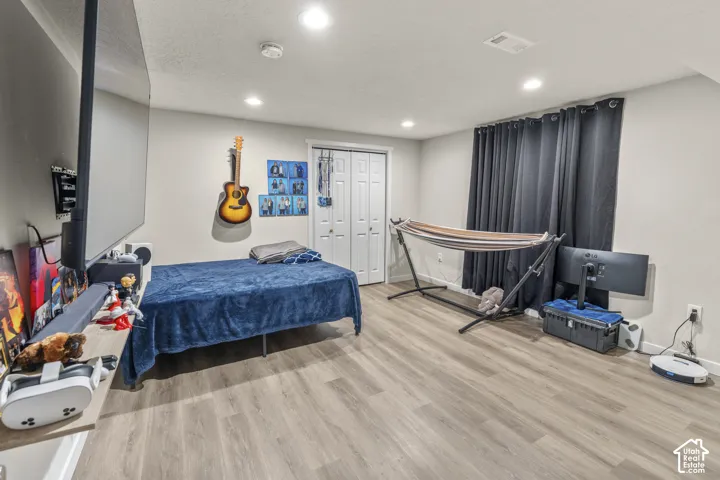 Recessed lighting, wood-finish flooring, and light-toned walls