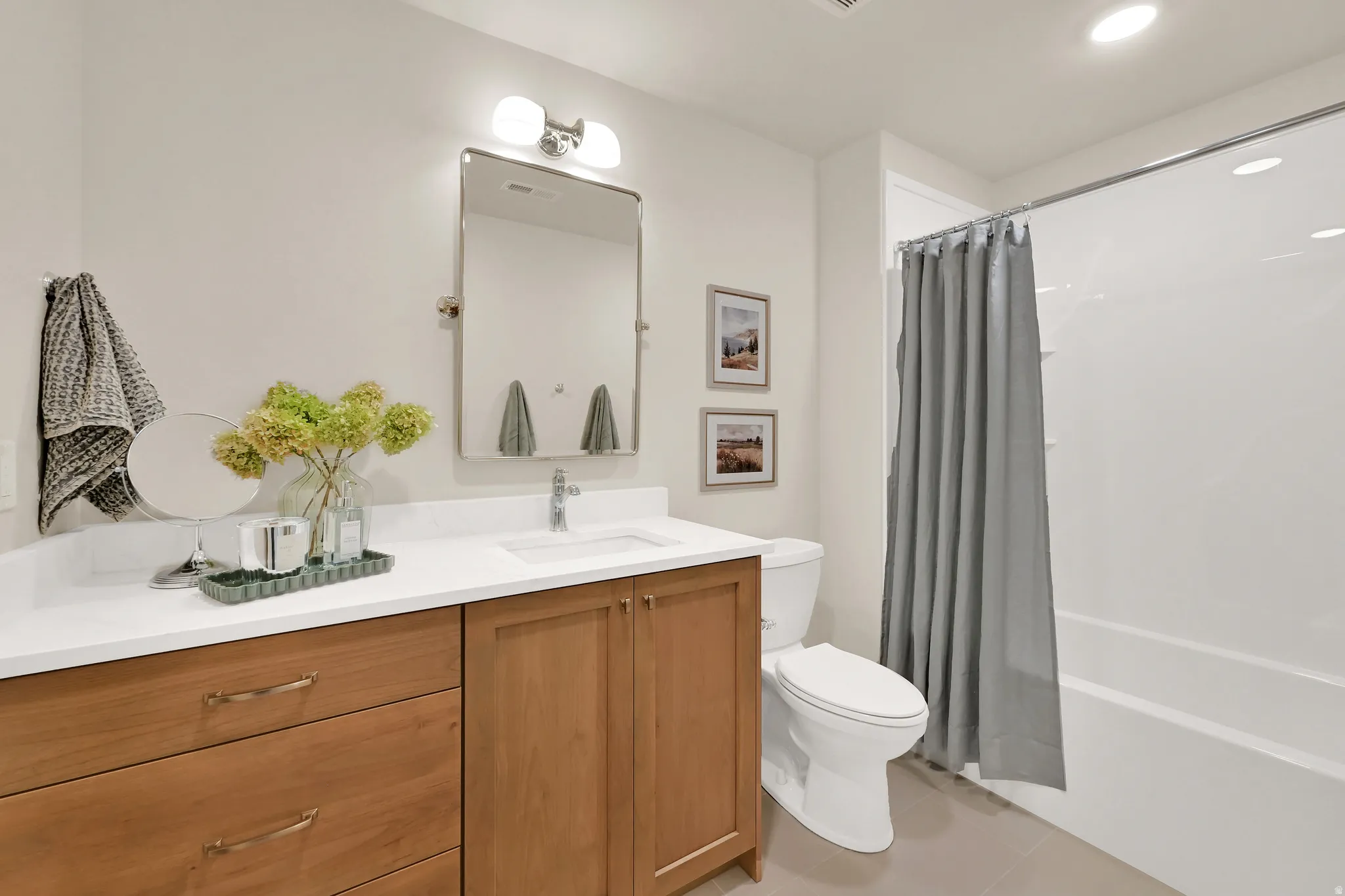 Bathroom featuring a single vanity with wood-finish cabinetry, a white countertop, and an integrated sink