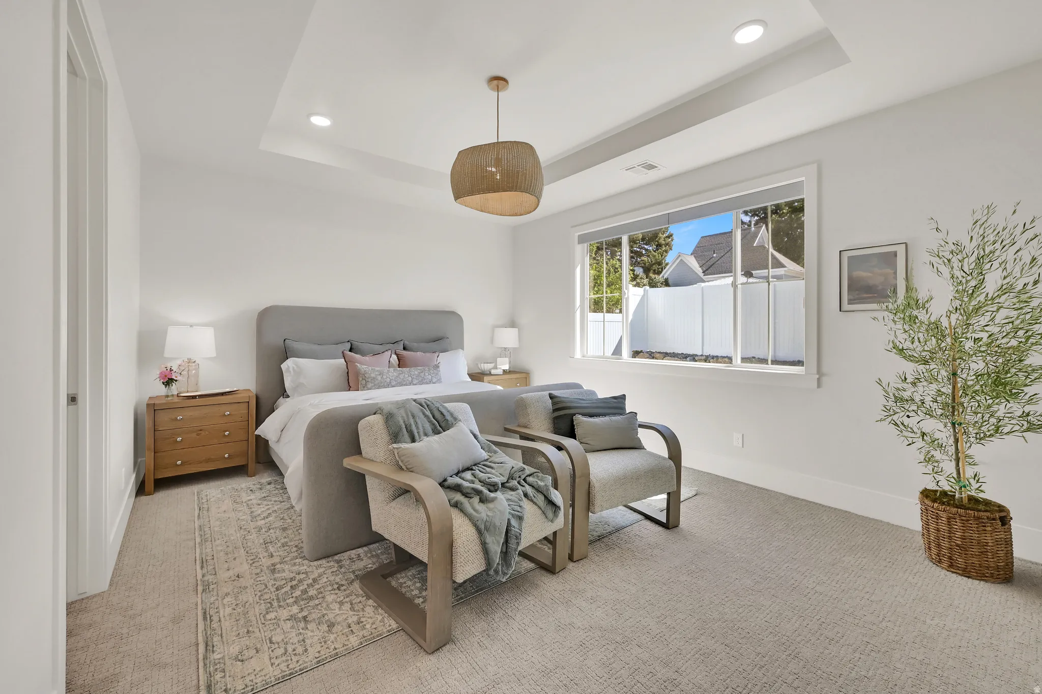 Tray ceiling with recessed lighting, large window, and carpeted flooring