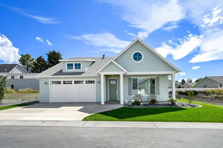 Light blue siding exterior with a pitched roof and a round attic window