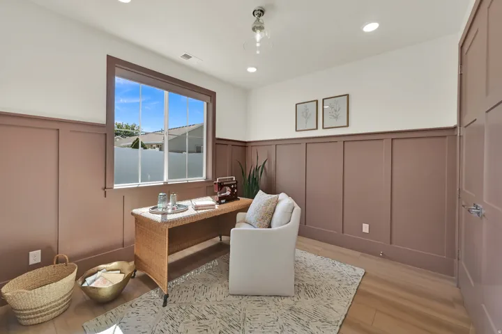 Board and batten wall paneling, recessed ceiling lighting, pendant light fixture, wood-finish flooring, and a large window