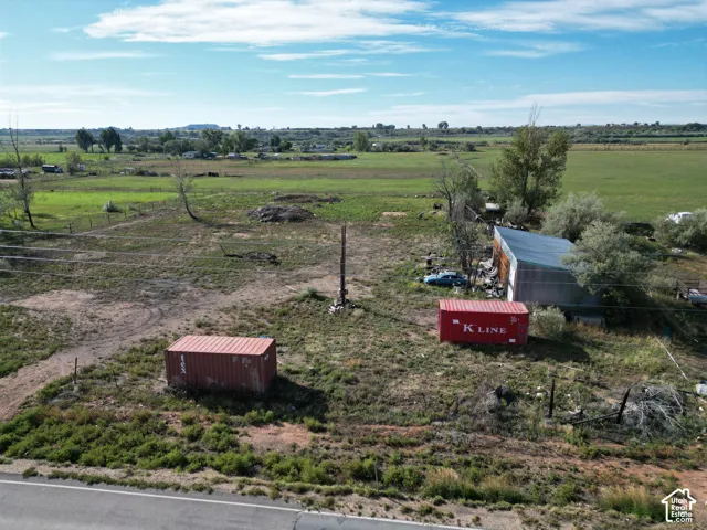 Expansive undeveloped land featuring a partial road frontage and two storage containers