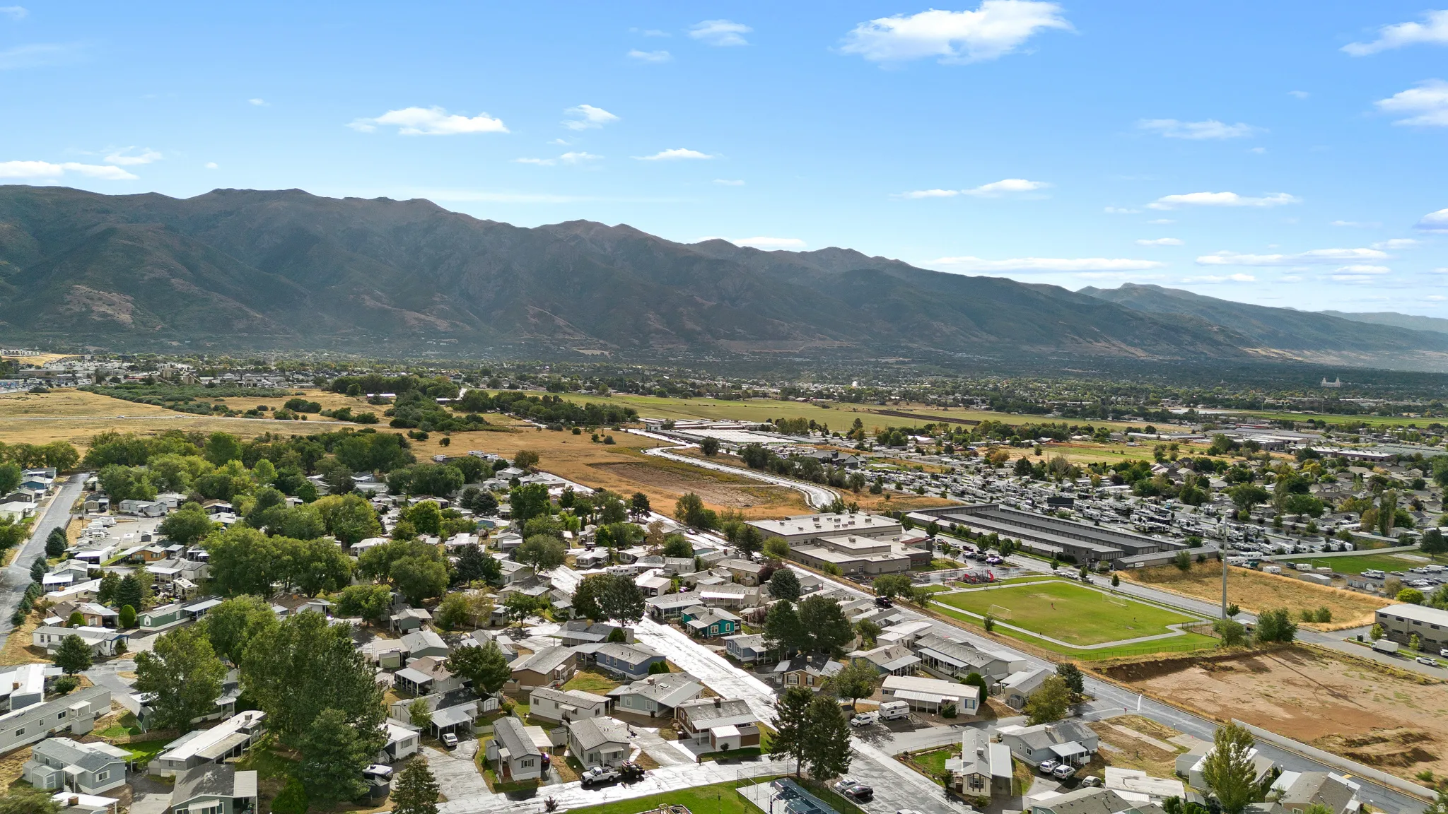 Expansive neighborhood with mature trees, surrounded by distant mountains