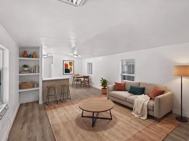 Vaulted white ceilings, wood-finish flooring, built-in shelving, and a breakfast bar with countertop