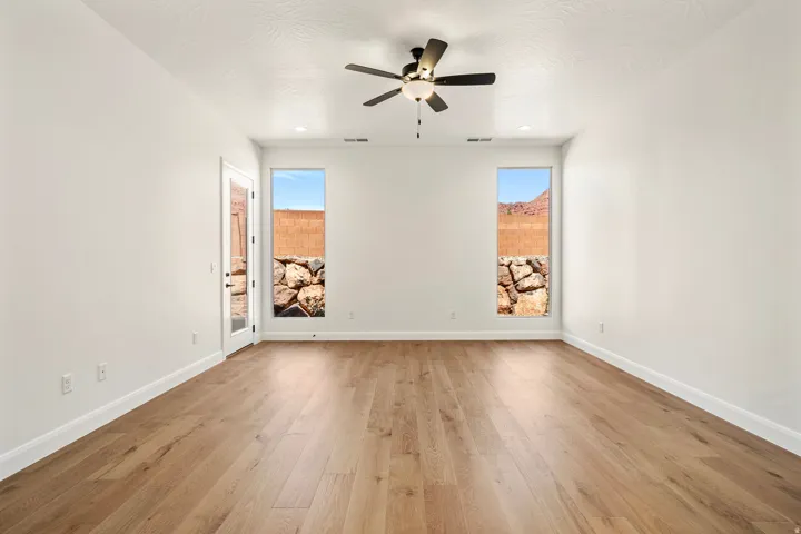Spacious room featuring wood-finish flooring, recessed lighting, and a ceiling fan