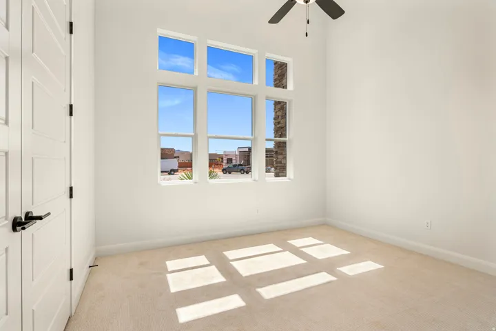 Vaulted ceiling, ceiling fan, multi-pane window, white paneled door, black hardware