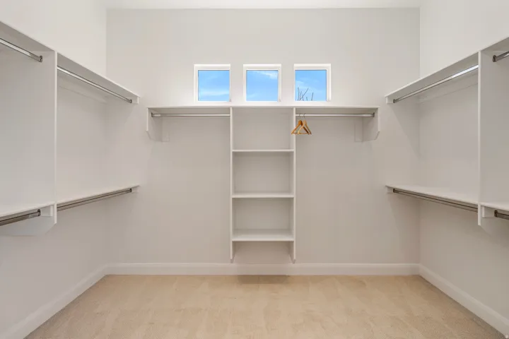 Built-in closet organization system with multiple hanging rods and shelving