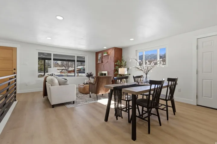 Spacious living area featuring light wood-finish flooring, recessed lighting, and large windows