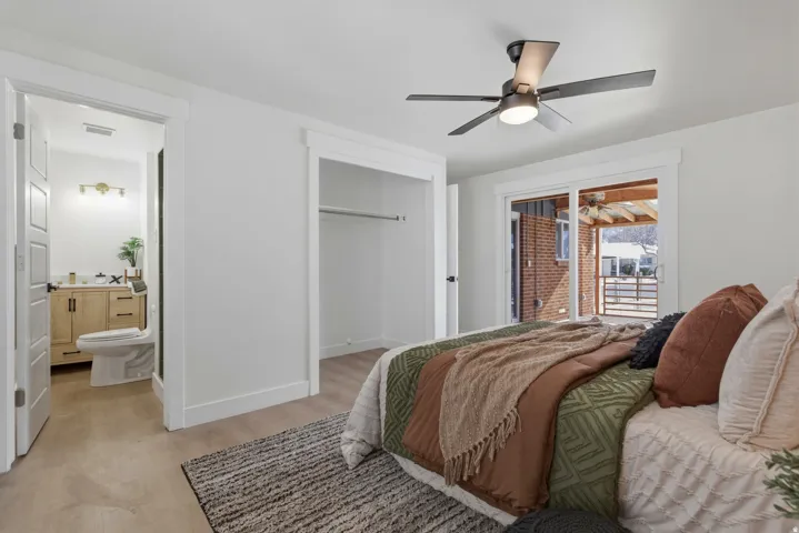 Wood-finish flooring, ceiling fan with integrated lighting, sliding glass door, and a built-in closet