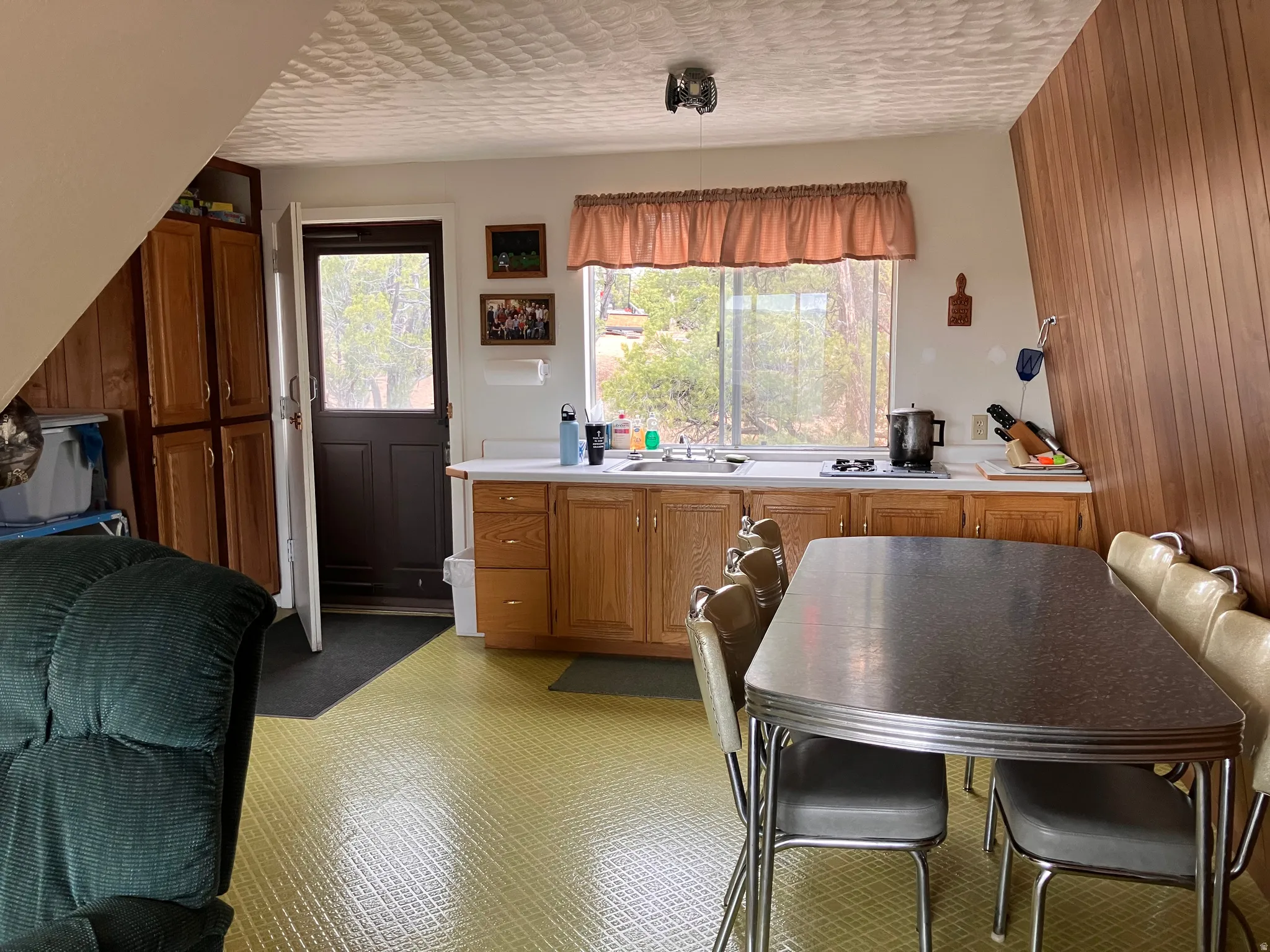 Kitchen area featuring wood-finish cabinetry, a stainless steel sink, and a window with natural light