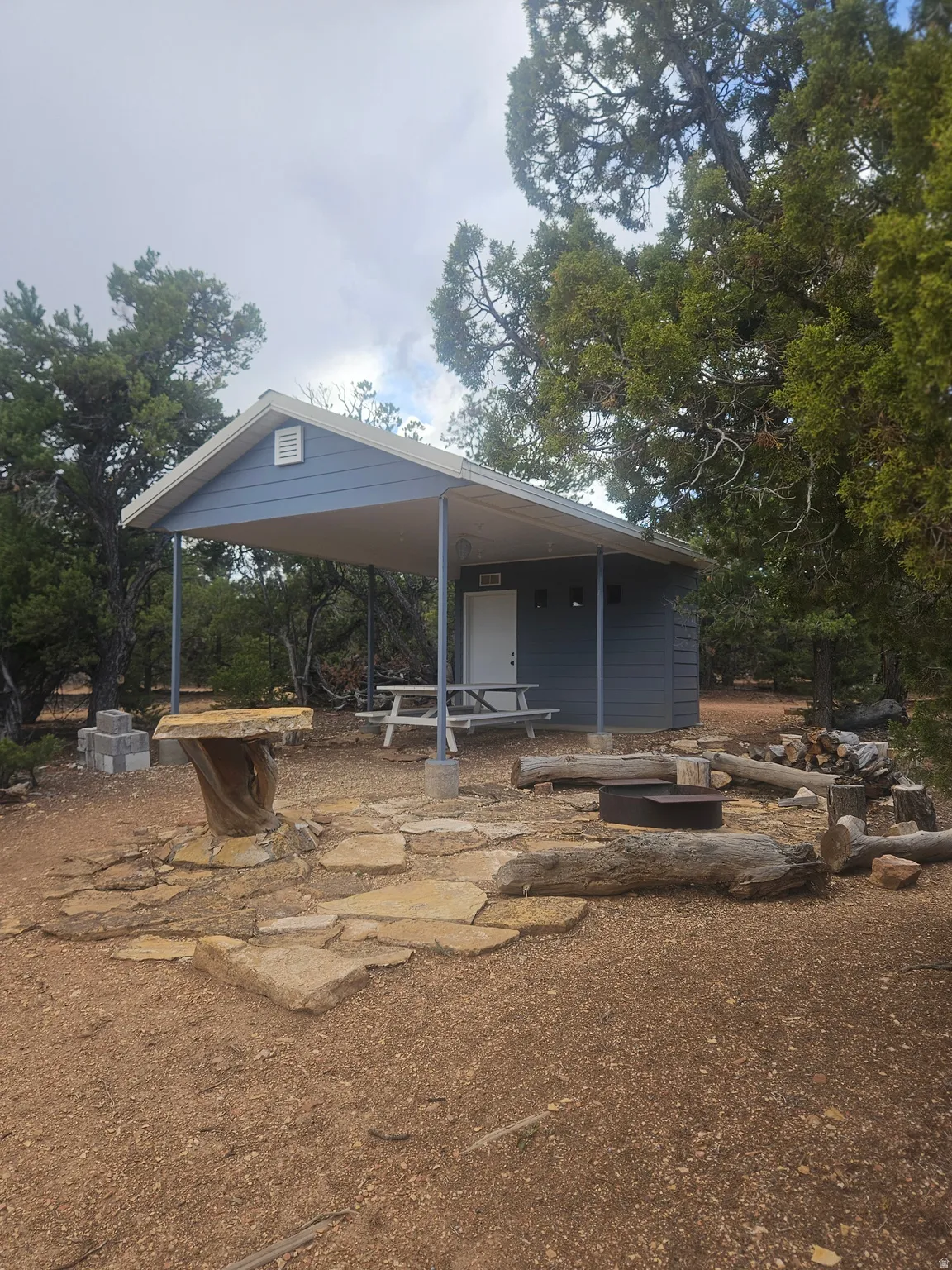 Charming cottage with a spacious covered porch, gabled roofline, and blue exterior siding