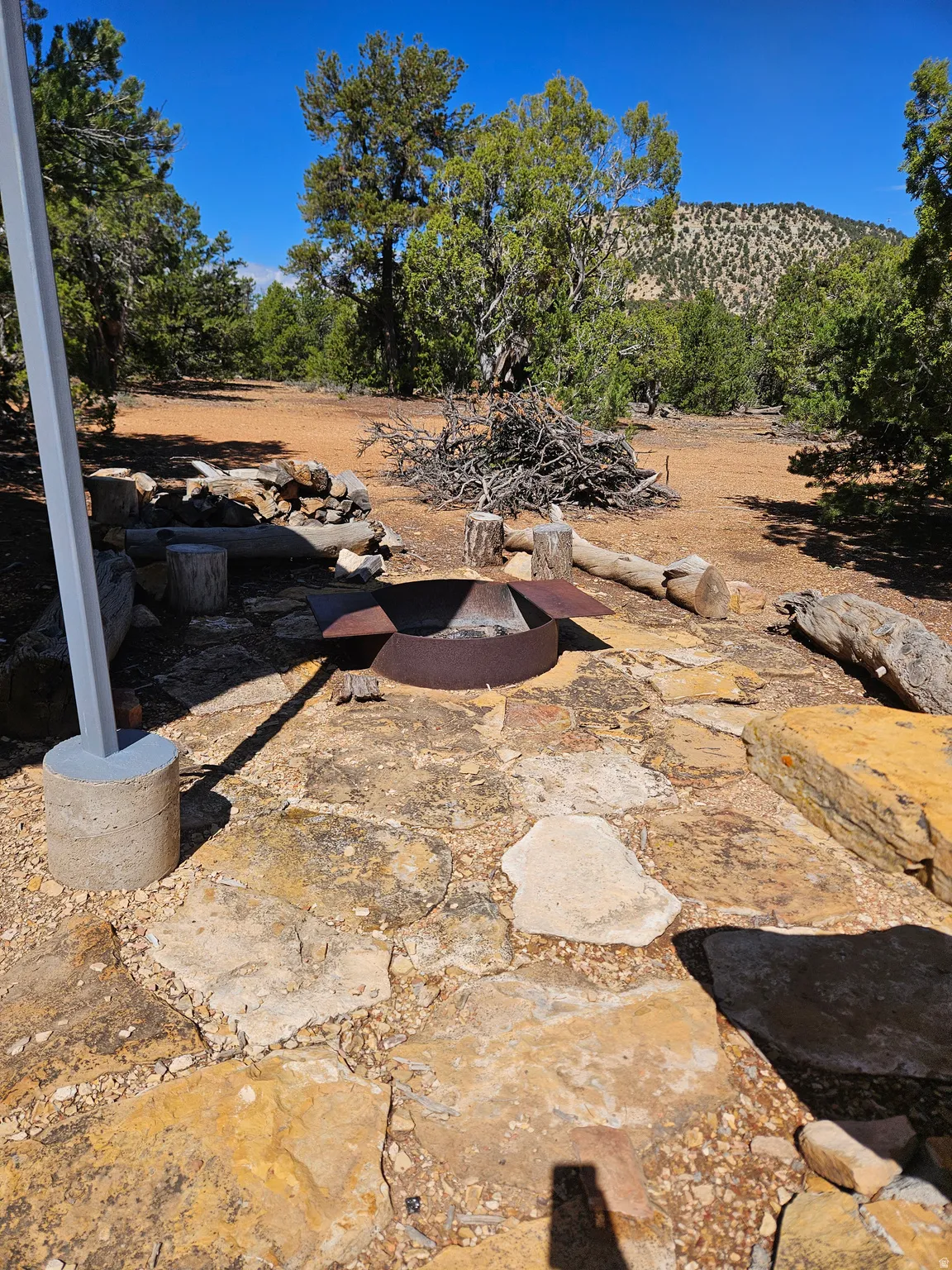 Natural stone paver patio featuring a built-in metal fire pit