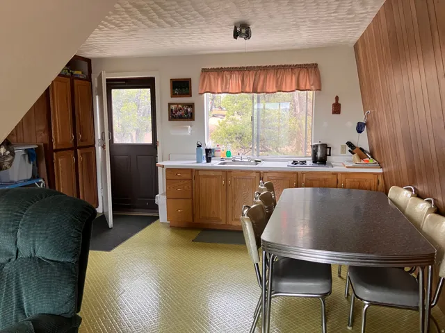 Kitchen area featuring wood-finish cabinetry, a stainless steel sink, and a window with natural light