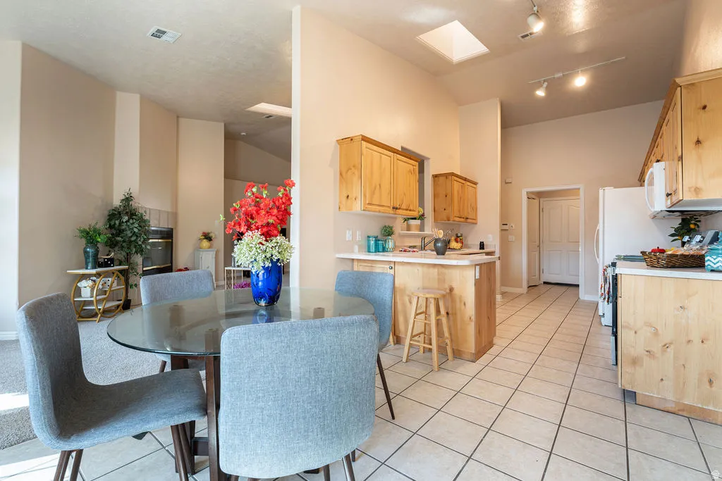 Vaulted ceilings, skylight, recessed lighting, tile flooring, and a built-in fireplace