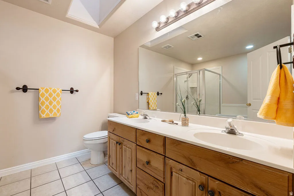 Dual basin vanity with wood-finish cabinetry and white countertops