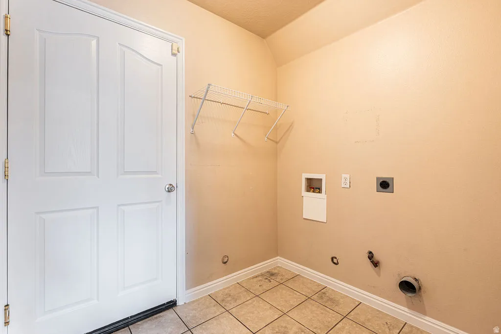 Utility room featuring tile flooring and a wire storage shelf