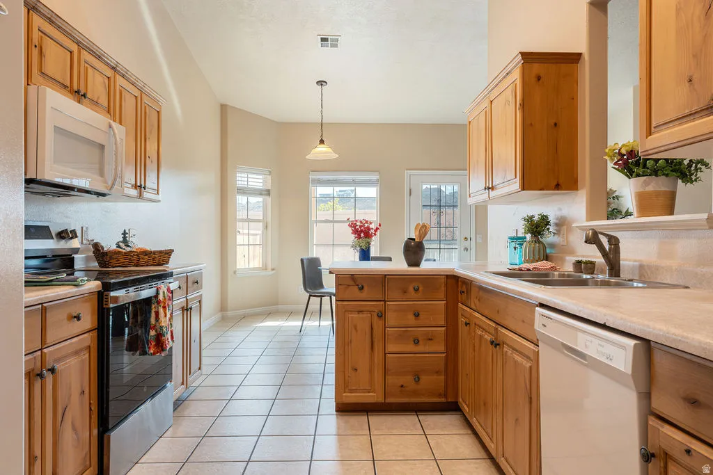 Kitchen featuring wood-finish cabinetry, tile flooring, and integrated appliances